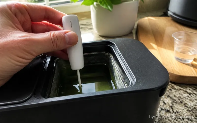 pH meter probe being lowered into a hydroponic reservoir with green nutrient solution
